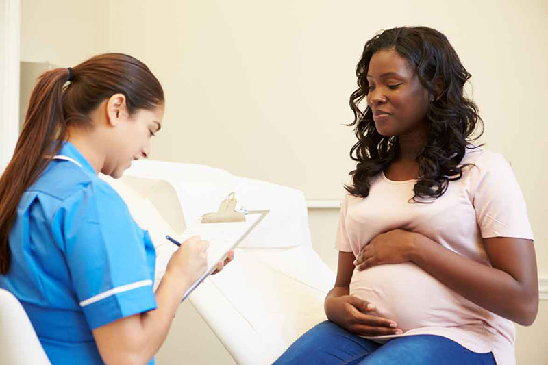 pregnant woman talking to nurse
