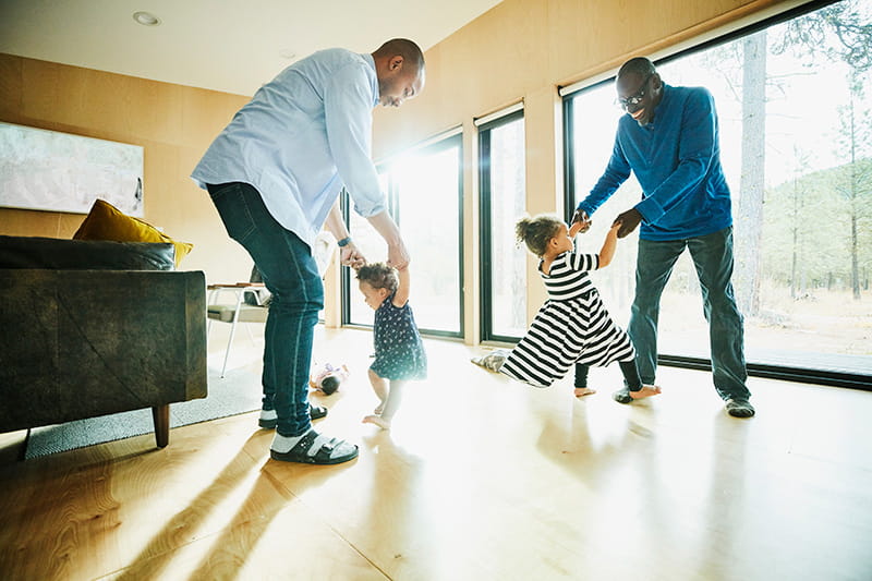 Abuelo y padre bailando con sus hijas en casa