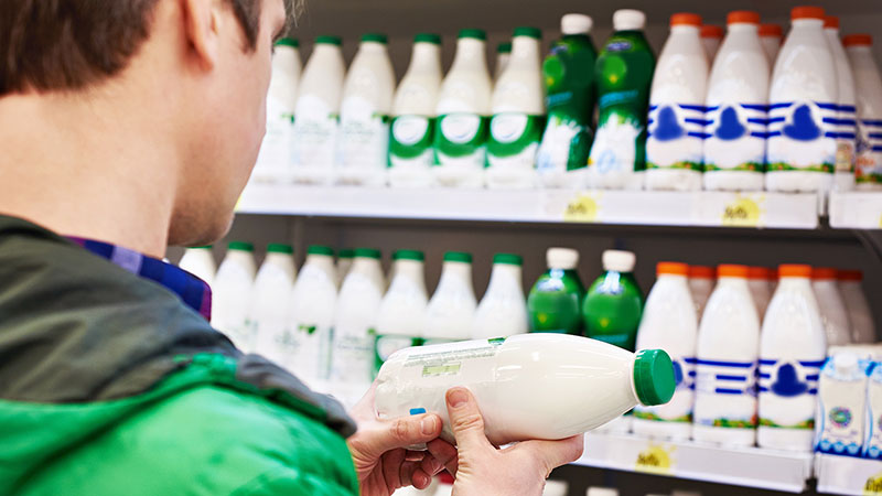 Man reading milk bottle label