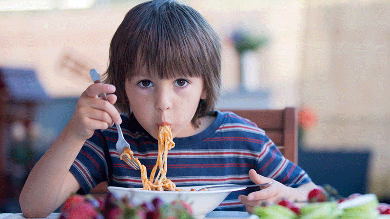 Niño comiendo espaguetis