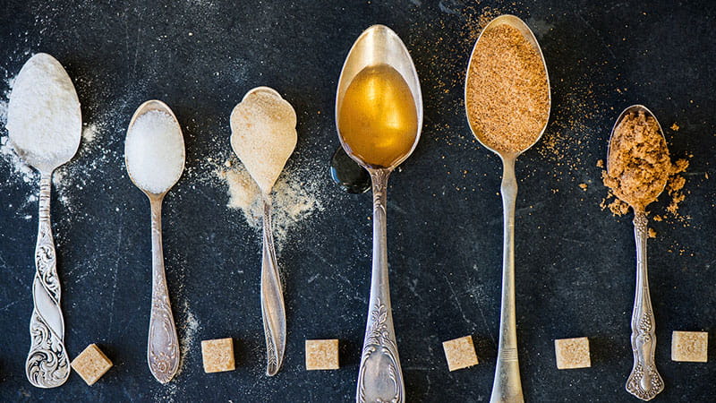 spoonfuls of different kinds of sugar sweeteners