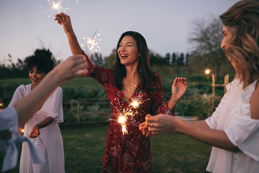 happy friends playing with sparklers outdoors happy friends playing with sparklers outdoors