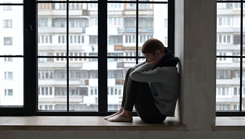 sad woman in windowsill