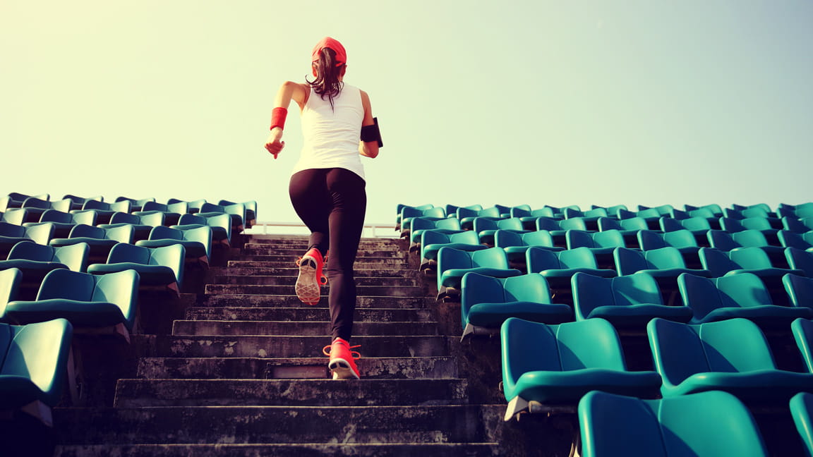 woman running up stadium stairs