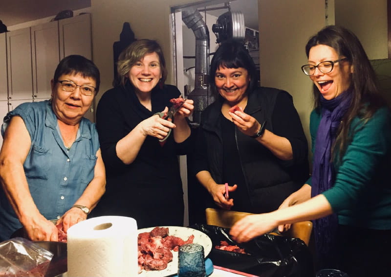 Dr. Allison Kelliher (far right) works with her family and friends to make ground moose meat to share with family. From left: Her mom, Trudy Kelliher; friend Sarah; and sister Sonya Kelliher-Combs. (Photo courtesy of Dr. Allison Kelliher)