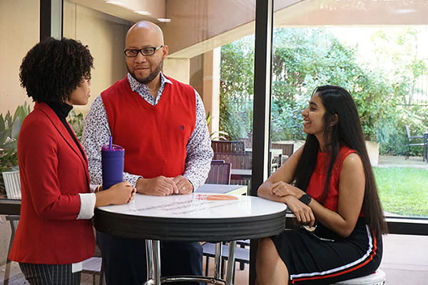 Three AHA employees converse at a table at National Center
