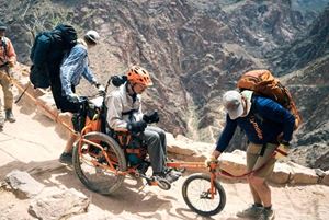 Geoff en su bicicleta modificada, mitad silla de ruedas y mitad bicicleta de montaña