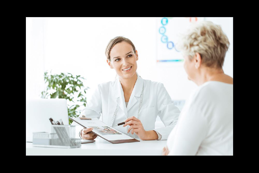 smiling female doctor discussing notes with woman patient