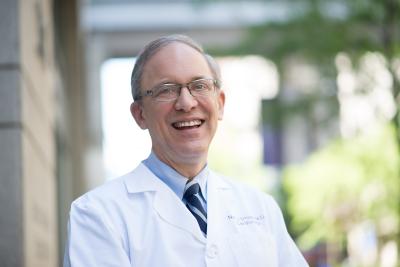 Dr. Neil Stone smiling in white coat
