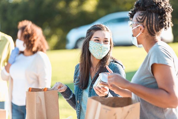 voluntarios con mascarillas distribuyen alimentos enlatados voluntarios con mascarillas distribuyen alimentos enlatados