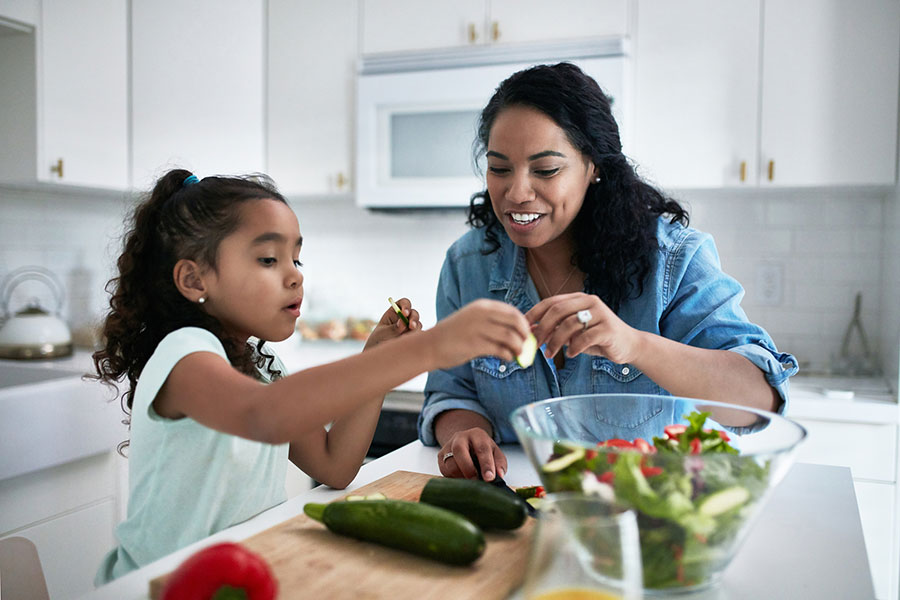 Mom and daughter make salad in kitchen Mom and daughter make salad in kitchen