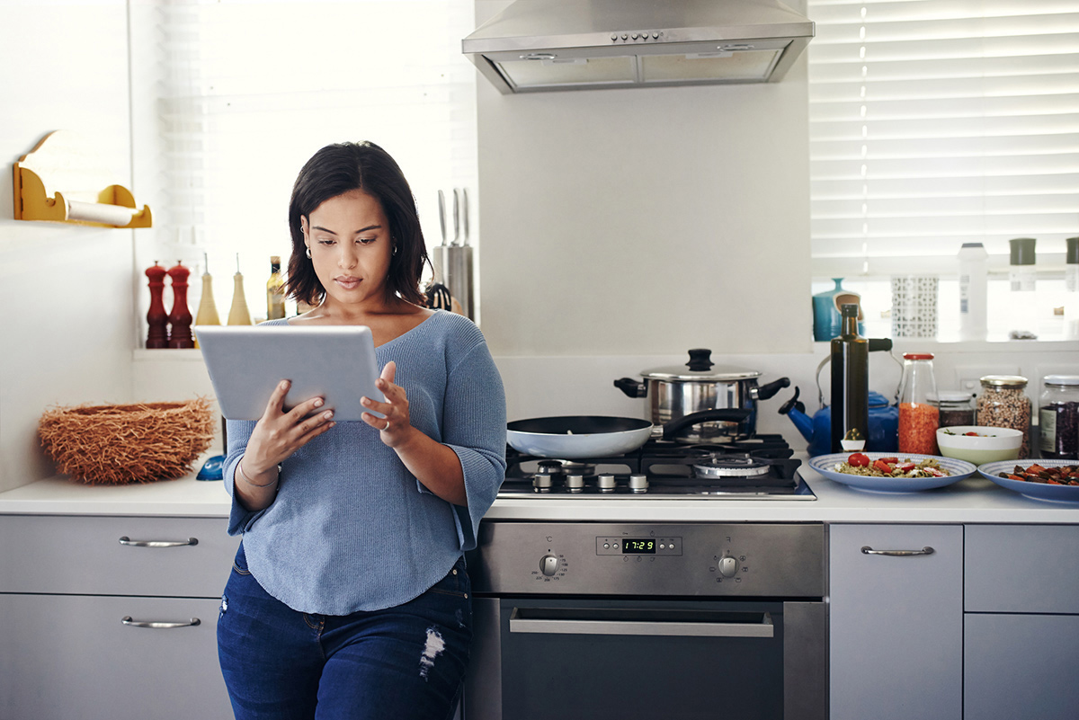 mujer que utiliza una tableta en la cocina mujer que utiliza una tableta en la cocina