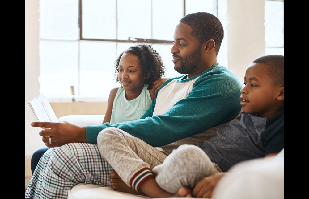 father reading to kids on couch