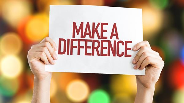 Manos sujetando una señal que dice Make A Difference