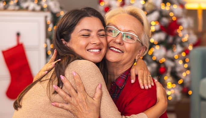 Two women hugging near the Christmas Tree