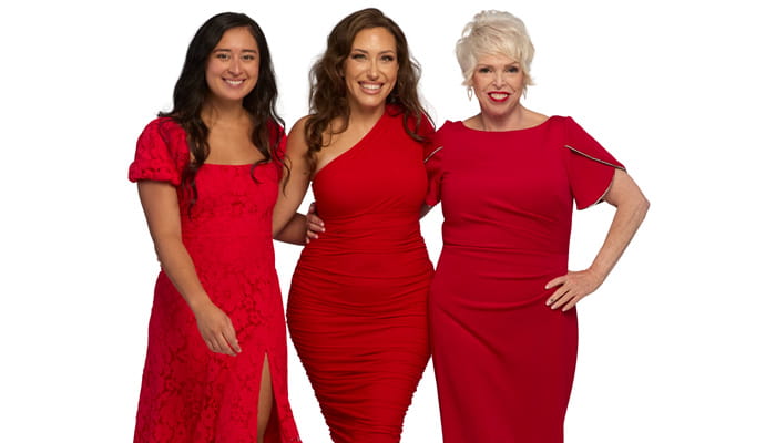 Three women from the Go Red for Women 2026 Class of Survivors posing in red dresses.