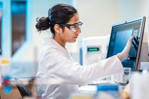 A woman scientist working on a computer in a laboratory. 