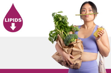 A woman is holding a bag of produce and balancing an asparagus spear on her top lip.