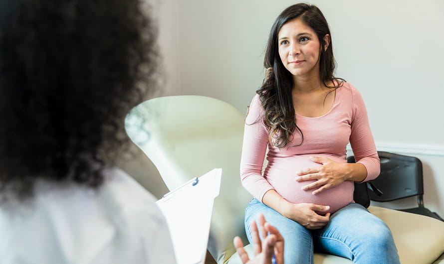 Young pregnant woman visiting with her doctor.
