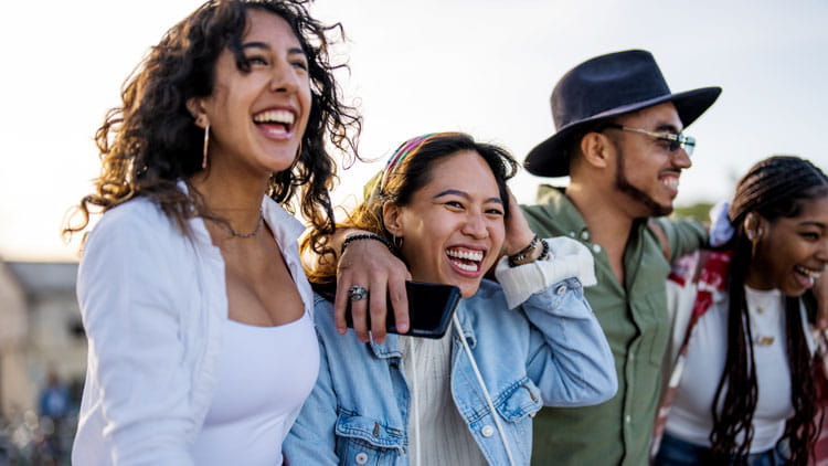 Group of happy young adults walking together outside. 