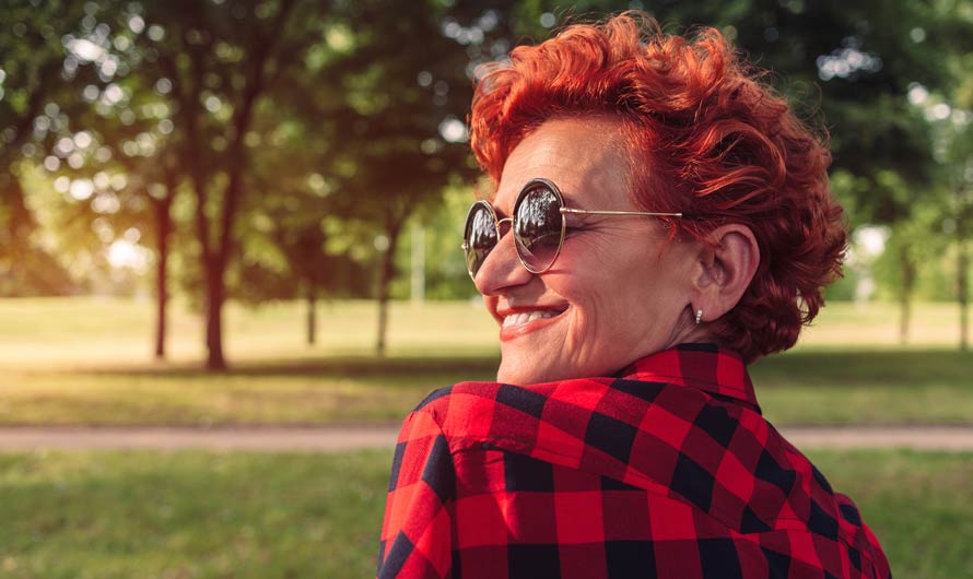 Woman sitting in a park smiling.