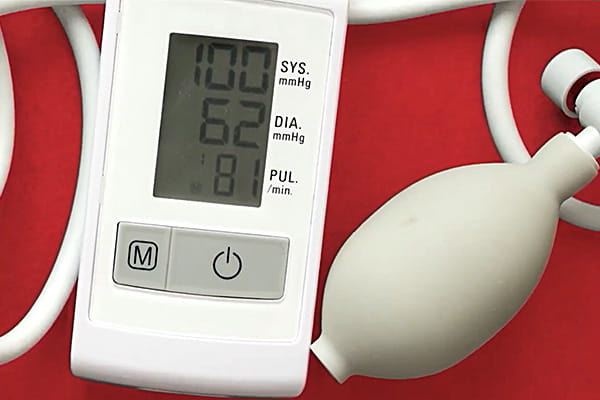 Portable blood pressure monitor against a red background