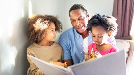 father reading to young daughters father reading to young daughters