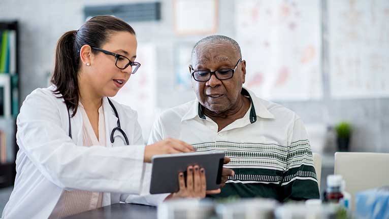 Elderly male patient going over results with female doctor