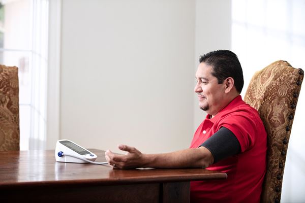 Hispanic man checking his blood pressure