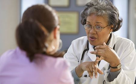 middle-aged doctor counsels patient middle-aged doctor counsels patient