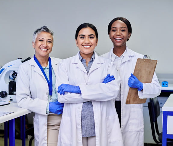 Three women healthcare professionals in white lab coats