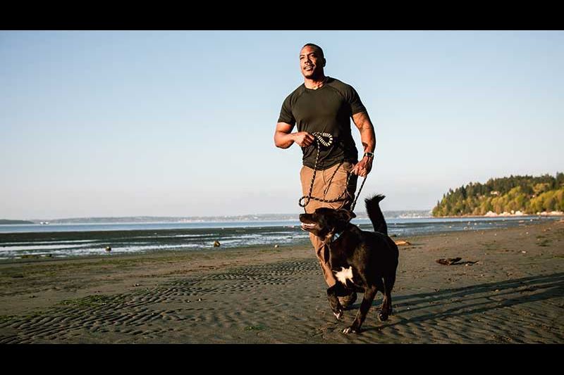 hombre corriendo con su perro en la playa