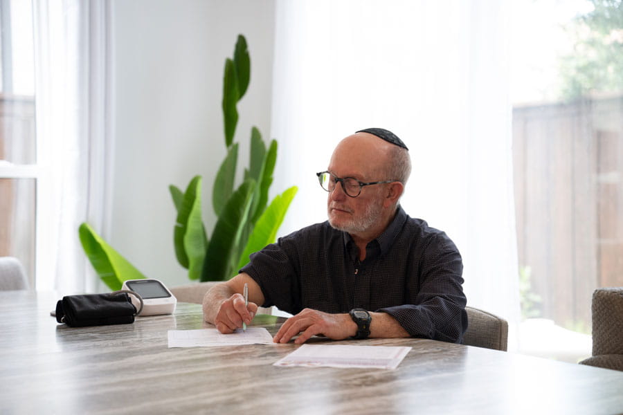 Man checking his blood pressure at home and logging it