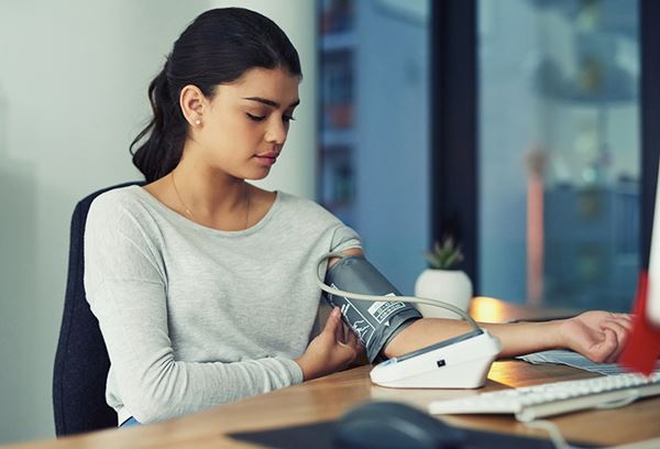 woman taking blood pressure at work woman taking blood pressure at work